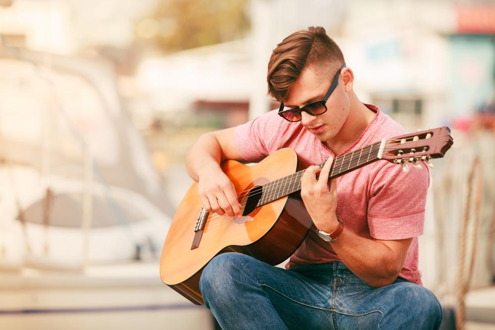 Man with prescription sunglasses and guitar from Plano Otometrist